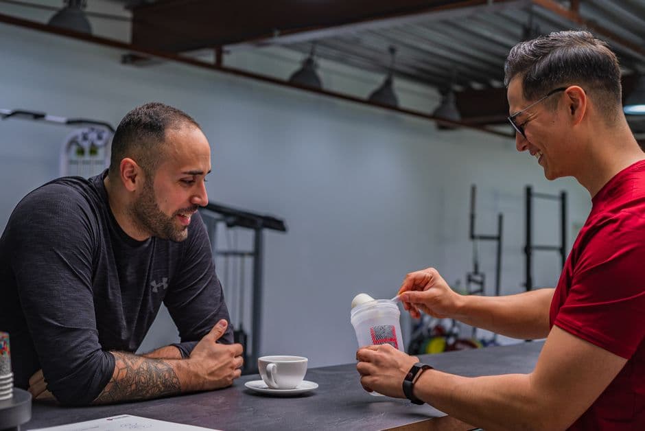 Mann blander proteinpulver i en shaker etter trening
